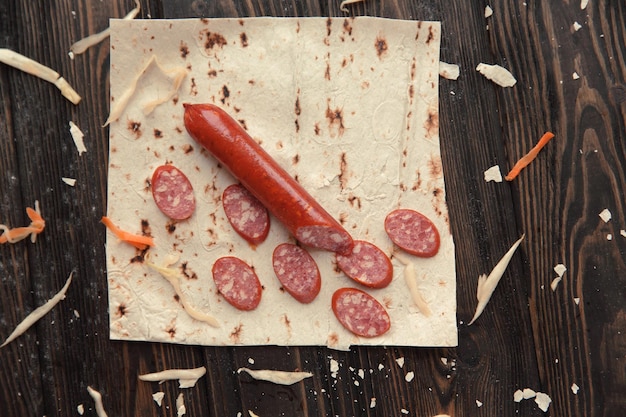 Salami in Scheiben geschnitten auf Fladenbrot. Vorbereitung von Shawarma. Foto mit Textfreiraum