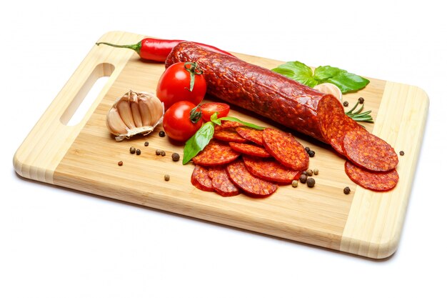 Foto salami italiano o chorizo español en tabla de cortar de madera