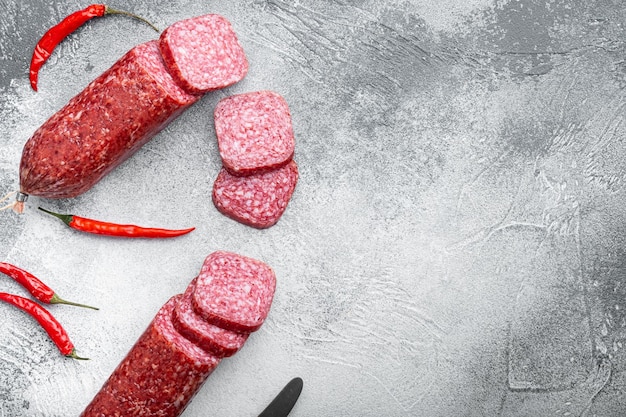 Salami mit Zutaten auf grauem Steintisch Hintergrund Draufsicht flach lag mit Kopierraum für Text