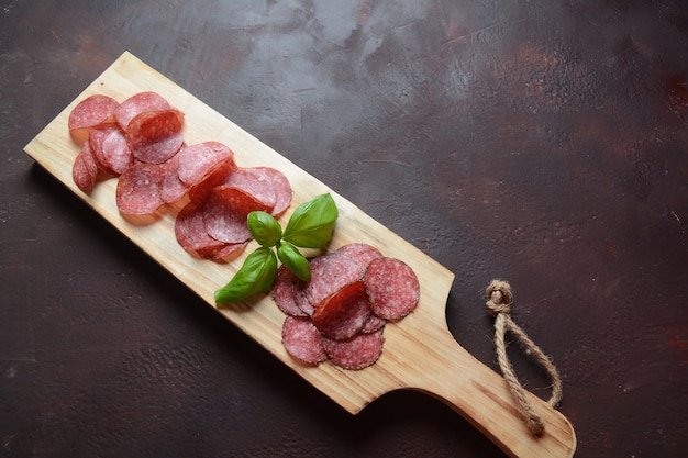 Salami en rodajas sobre tabla de cortar