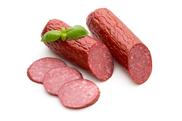 Salami salchicha ahumada, hojas de albahaca en el recorte de fondo blanco.