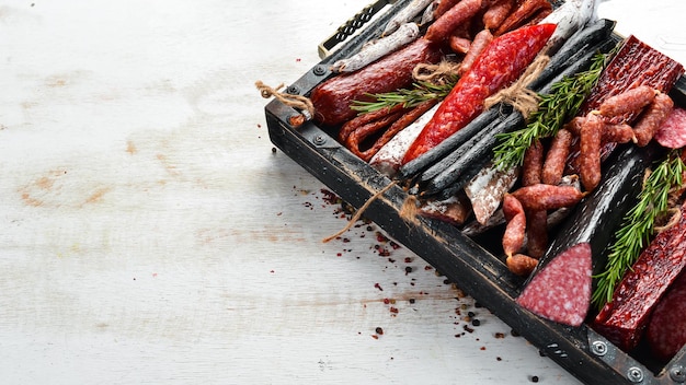 Salami salchichas especias y productos cárnicos en una caja de madera Vista superior Espacio libre para su texto