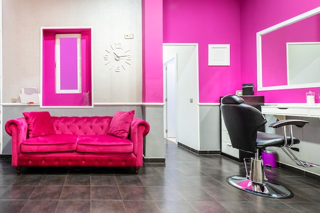 Salão de beleza com sofá chesterfield estofado em tecido veludo rosa e cadeira para corte de cabelo e maquiagem