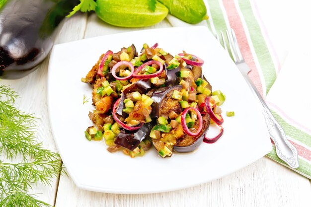 Salat aus Auberginen und Gurken mit roten Zwiebeln im Teller an Bord