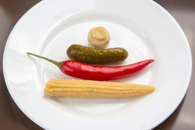 Salat aus eingemachten und eingelegten Pilzen, Gurken und rotem Pfeffer auf einem weißen Teller. Essen und Gemüse. Diät und Gewichtsverlust