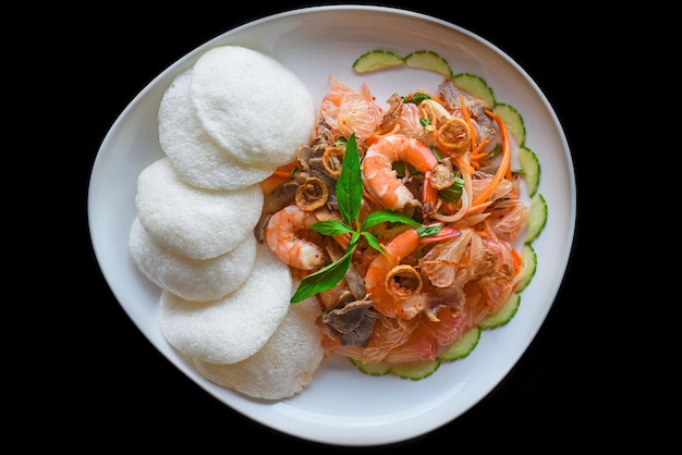 Salat aus Garnelen und Grapefruit isoliert auf Draufsicht des schwarzen Hintergrundes