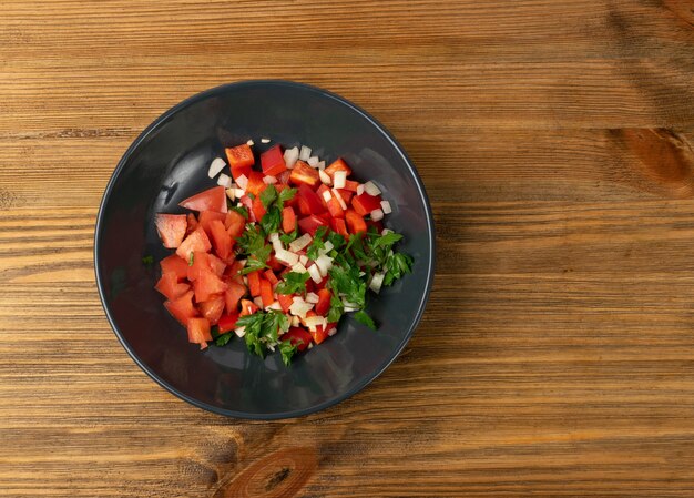 Salat aus gehacktem Gemüse mit Tomaten, Paprikawürfeln, Petersilie, Zwiebeln und Knoblauch