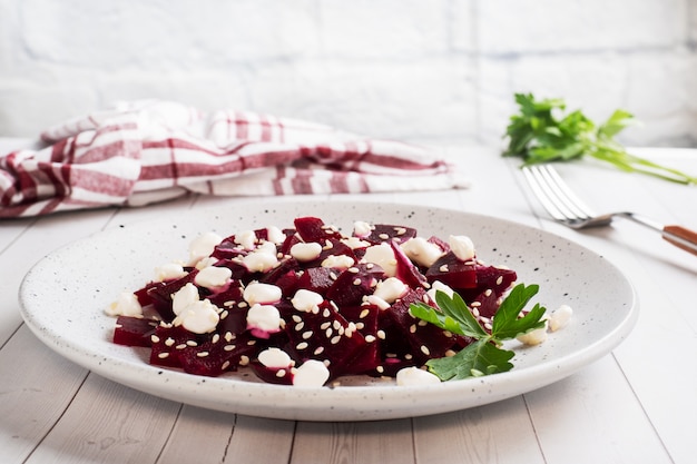 Salat aus gekochter Rote Beete und Getreidequark mit Sesam auf einem Teller.