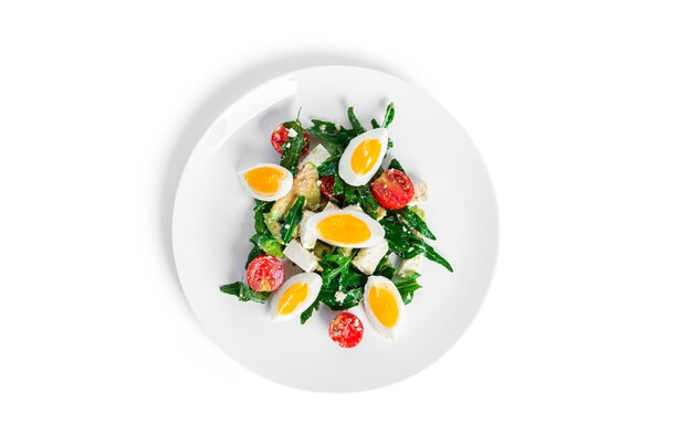 Salat aus Rucola, Avocado, Kirschtomaten und Eiern isoliert auf weißem Hintergrund. Grüner Salat. Vegetarischer Salat. Foto in hoher Qualität