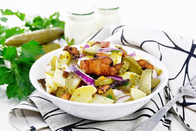 Salat aus Salzkartoffeln, gebratenem Speck, roten Zwiebeln und eingelegten Gurken, gewürzt mit Getreidesenf