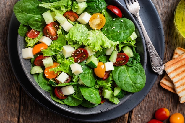 Salat aus Spinat-Kirschtomaten und Käse auf einem Teller