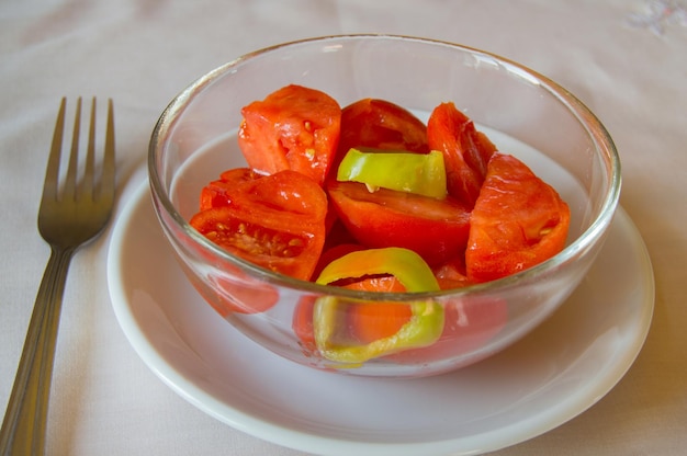 Salat aus Tomaten und Paprika in Glasschüssel mit Gabel