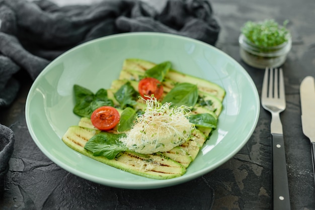 Salat aus Zucchinischeiben mit Kirschtomate, Frischkäse und Mikrogrüns. Vegetarisches Essen