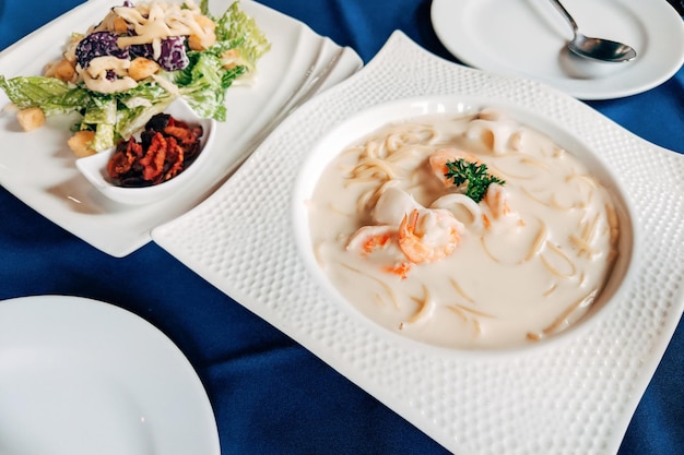 Salat Cesar und Meeresfrüchte Spaghetti flach lag Draufsicht Tisch mit italienischem Essen