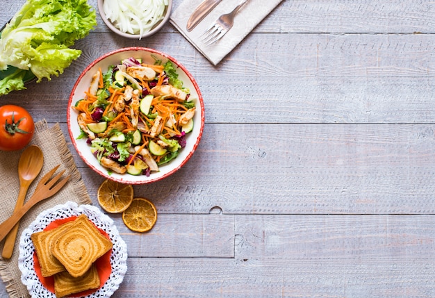 Salat der Hühnerbrust mit Zucchini- und Kirschtomaten, auf einem hölzernen Hintergrund