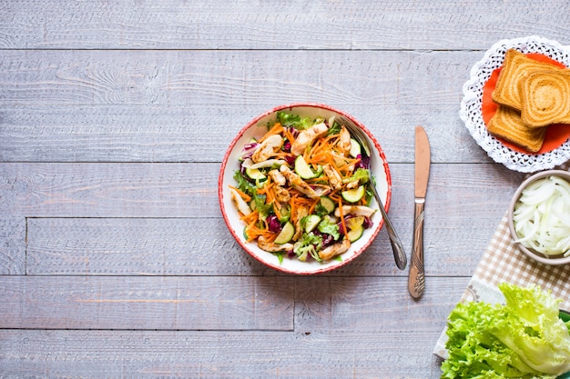 Foto salat der hühnerbrust mit zucchini und kirschtomaten, auf einem hölzernen hintergrund