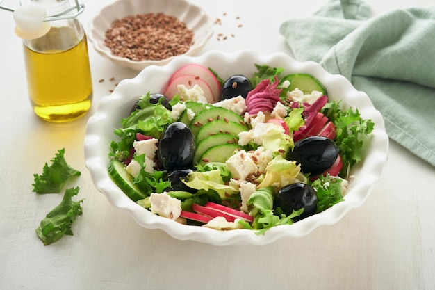 Salat, Gurken-Rettich-Salat mit Hüttenkäse und Leinsamen, Olivenöl-Salat, gesunde Ernährung, Diät-Menü und ausgewogene Ernährung, Ansicht von oben