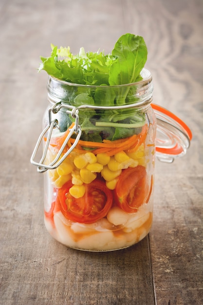 Salat im Glas mit Frischgemüse auf Holztisch