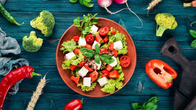 Salat in einem Teller Feta-Käse Kirschtomaten Paprikasalat Gesunde Ernährung Auf einem blauen Holztisch Tisch Draufsicht Freier Platz für Text