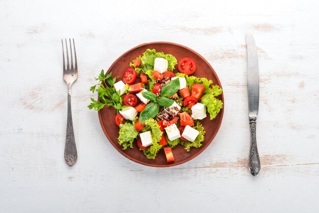 Salat in einem Teller Feta-Käse Kirschtomaten Paprikasalat Gesunde Ernährung Auf einem weißen Holztisch Tisch Draufsicht Freier Platz für Text