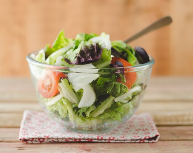 Salat in Glasschüssel über Holz