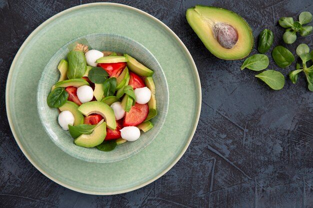 Salat mit Avocado-Kirschtomaten, Mozzarella und Basilikum Gesundes Essen reich an Vitaminen, Antioxidantien und Ballaststoffen