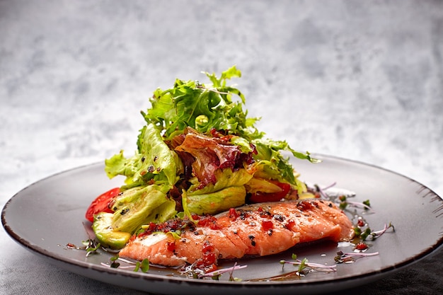 Salat mit Avocado und Lachs auf hellem Hintergrund