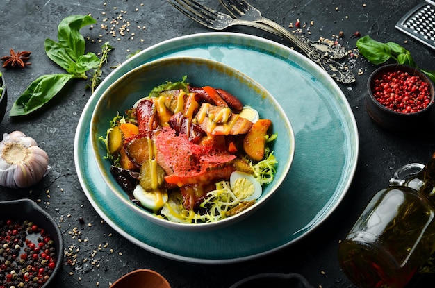 Salat mit bayerischen Bratwürsten und Kalbfleisch Draufsicht Rustikaler Stil