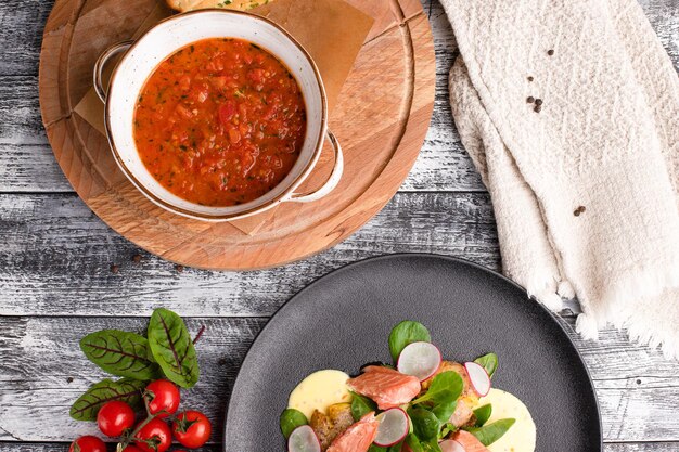 Salat mit Fisch- und Tomatensuppe auf einer Draufsicht des weißen hölzernen Hintergrundes Beschneidungspfad eingeschlossen