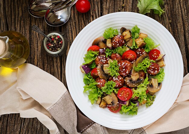 Salat mit Fleischbällchen, Auberginen, Champignons und Tomaten im asiatischen Stil. Gesundes Essen. Diät essen. Ansicht von oben. Flach liegen.