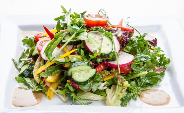 Salat mit frischem Frühlingsgemüse auf weißem Grund