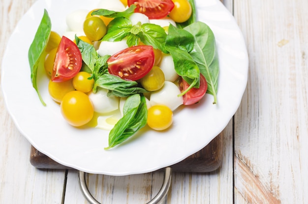 Salat mit frischem Mozzarella, Tomaten und Basilikum.