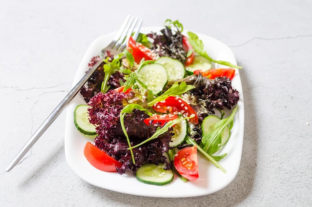 Salat mit frischen Salatblättern Rucola-Kirsch-Tomaten-Gurke