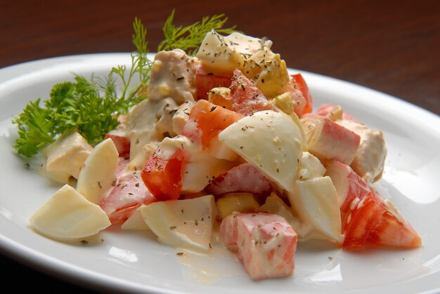 Salat mit frischen Tomaten, Eiern, Fleisch und Mayonnaise