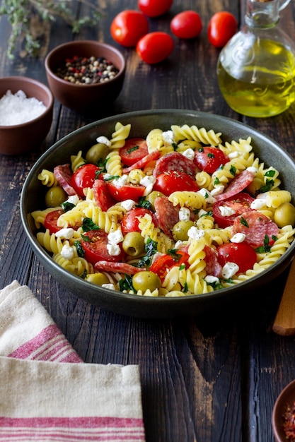 Salat mit Fusilli-Nudeln, Wurstoliven und Hüttenkäse italienisches Essen