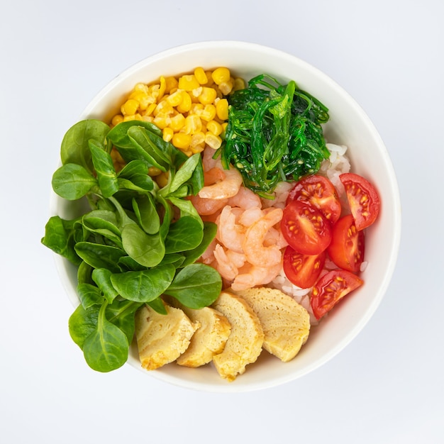 Salat mit Garnelen, Tomaten in einem weißen Teller auf weißem Grund