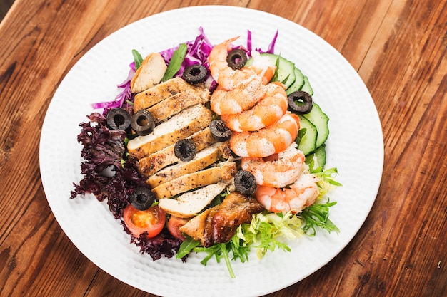 Salat mit Garnelen und Huhn auf einem Teller