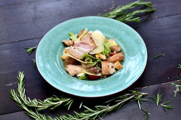 Salat mit gebratenem speck, parmesan, kirschtomaten und crackern