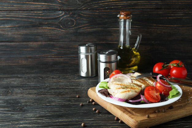 Salat mit gegrilltem Hähnchen auf Holztisch