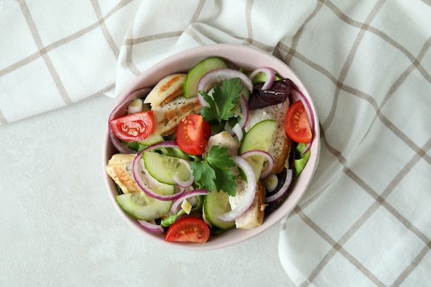 Salat mit gegrilltem Hähnchen auf weißem strukturiertem Tisch