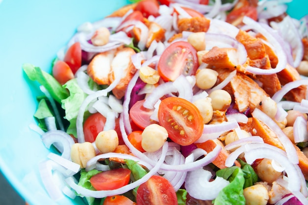 Salat mit gegrilltem Hähnchen, Kirschtomaten, Feldsalat, Kichererbsen, frischem Salat und Zwiebeln.