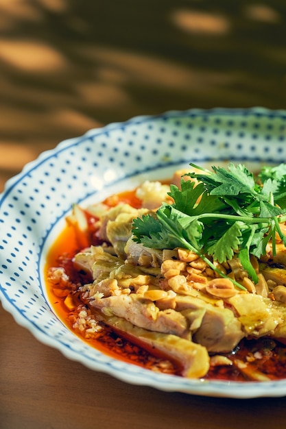 Salat mit gekochtem Hühnchen, Koriander, Erdnüssen in scharfer Sojasauce. Chinesische Küche.