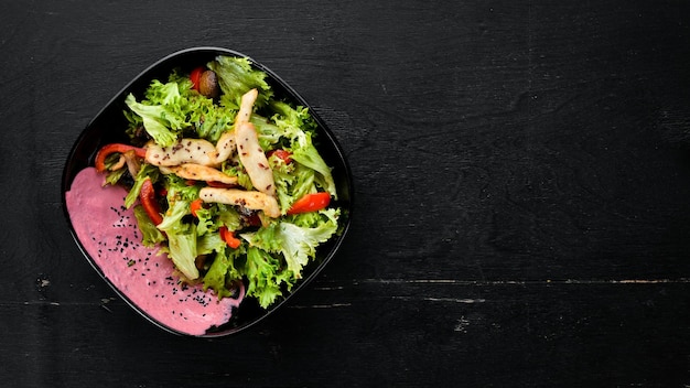 Salat mit Gemüse und Huhn Auf einem hölzernen Hintergrund Ansicht von oben Freier Platz für Ihren Text