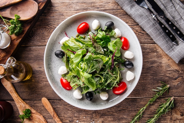 Salat mit grünen Mozzarella-Oliven und Tomaten