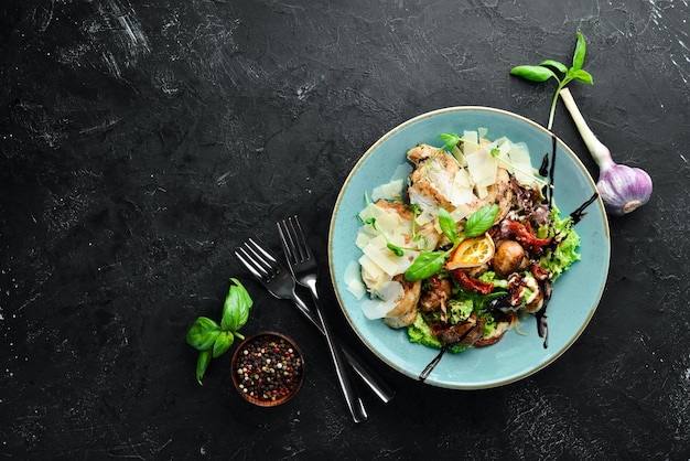 Salat mit Hähnchen, gegrilltem Gemüse und Parmesan In der Platte im rustikalen Stil Draufsicht Freier Platz für Ihren Text