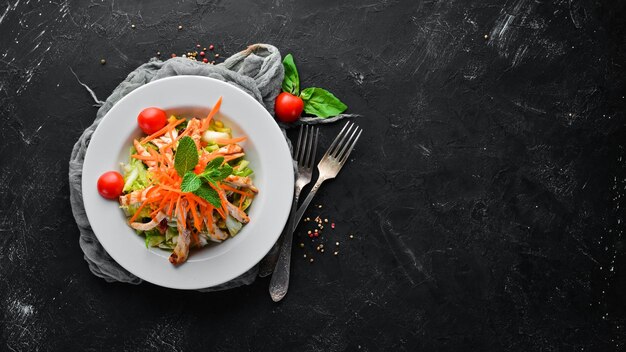 Salat mit Hähnchen und frischem Gemüse auf schwarzem Hintergrund Freier Platz für Ihren Text Ansicht von oben