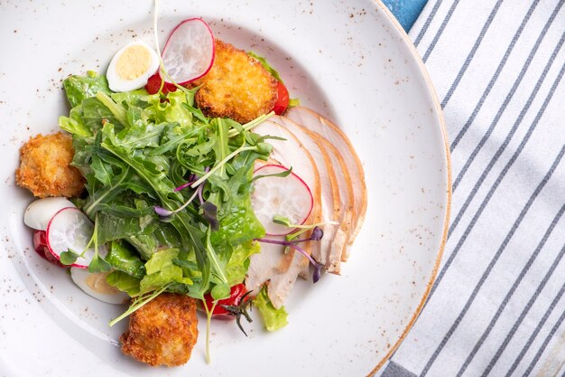 Salat mit Hähnchenfilet, Gemüse und Käse zu den Mahlzeiten