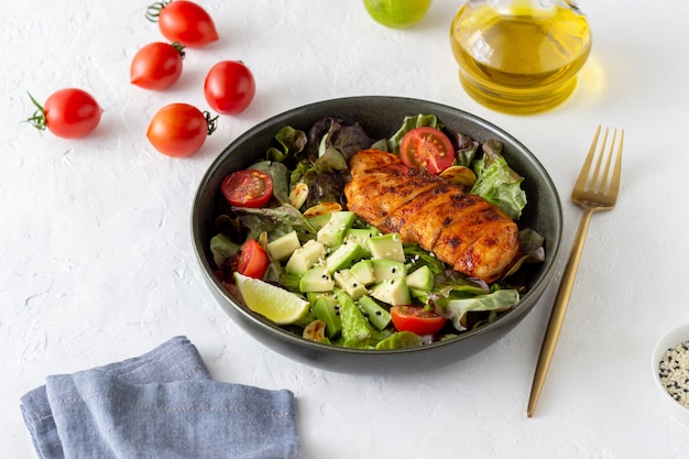 Salat mit Hühnchen, Avocado und Tomaten. Gesundes Essen. Vegetarisches Essen.