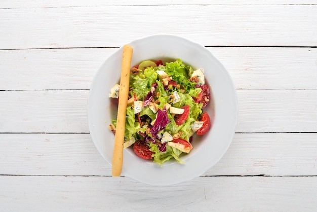 Salat mit Käse, Nüssen und frischem Gemüse Auf einem hölzernen Hintergrund Ansicht von oben Kopieren Sie Platz für Ihren Text