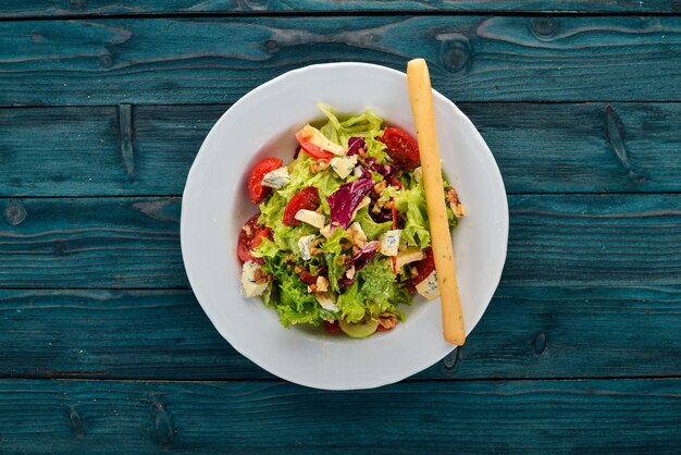 Foto salat mit käse, nüssen und frischem gemüse auf einem hölzernen hintergrund ansicht von oben kopieren sie platz für ihren text